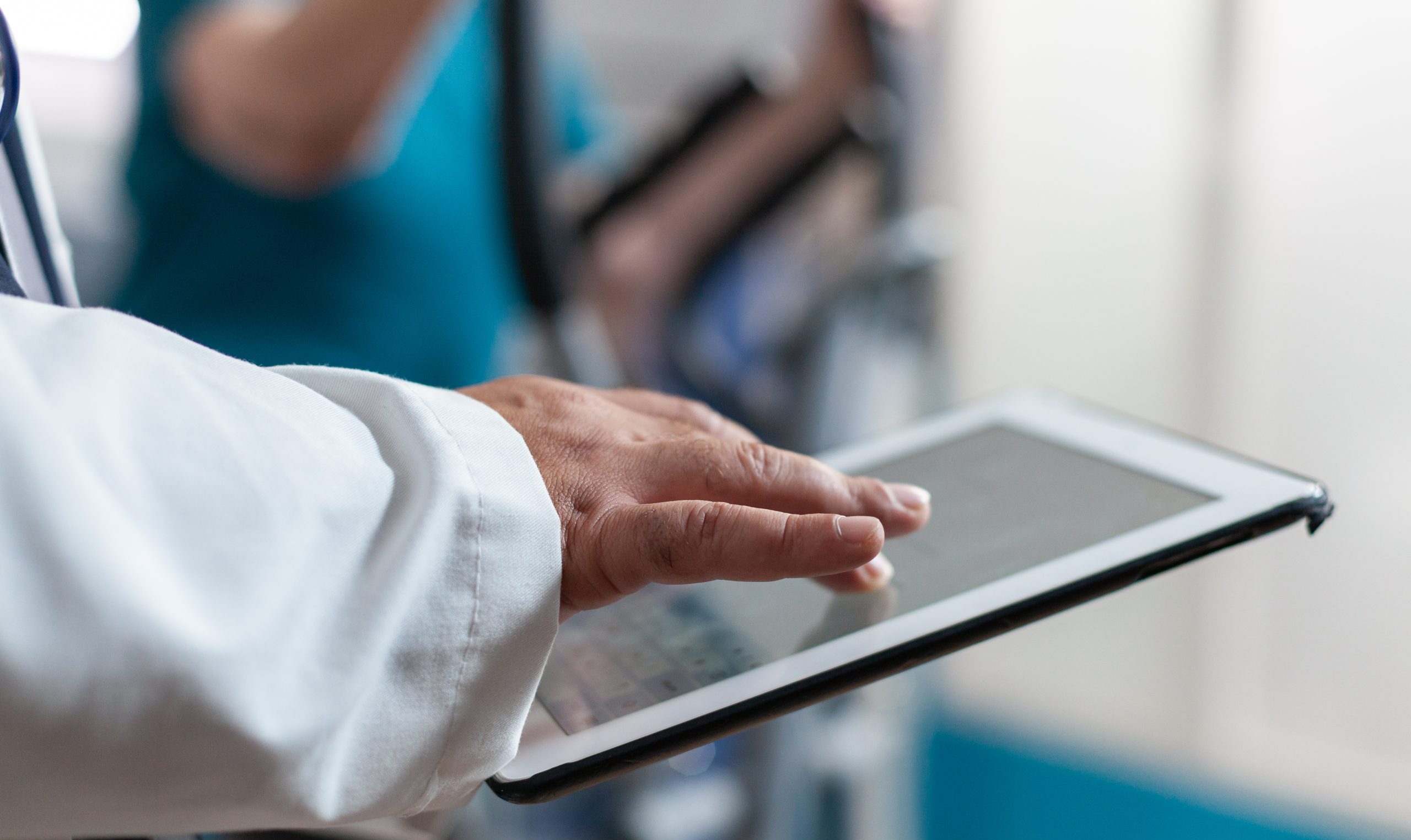 Close up of doctor using digital tablet with touch screen at physical recovery clinic. Medical worker holding modern device and technology to help patient with workout and fitness